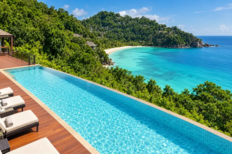 Infinity pool and timber deck overlooking a tropical bay