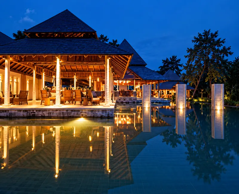 Resort pavilion reflected in a pool at twilight